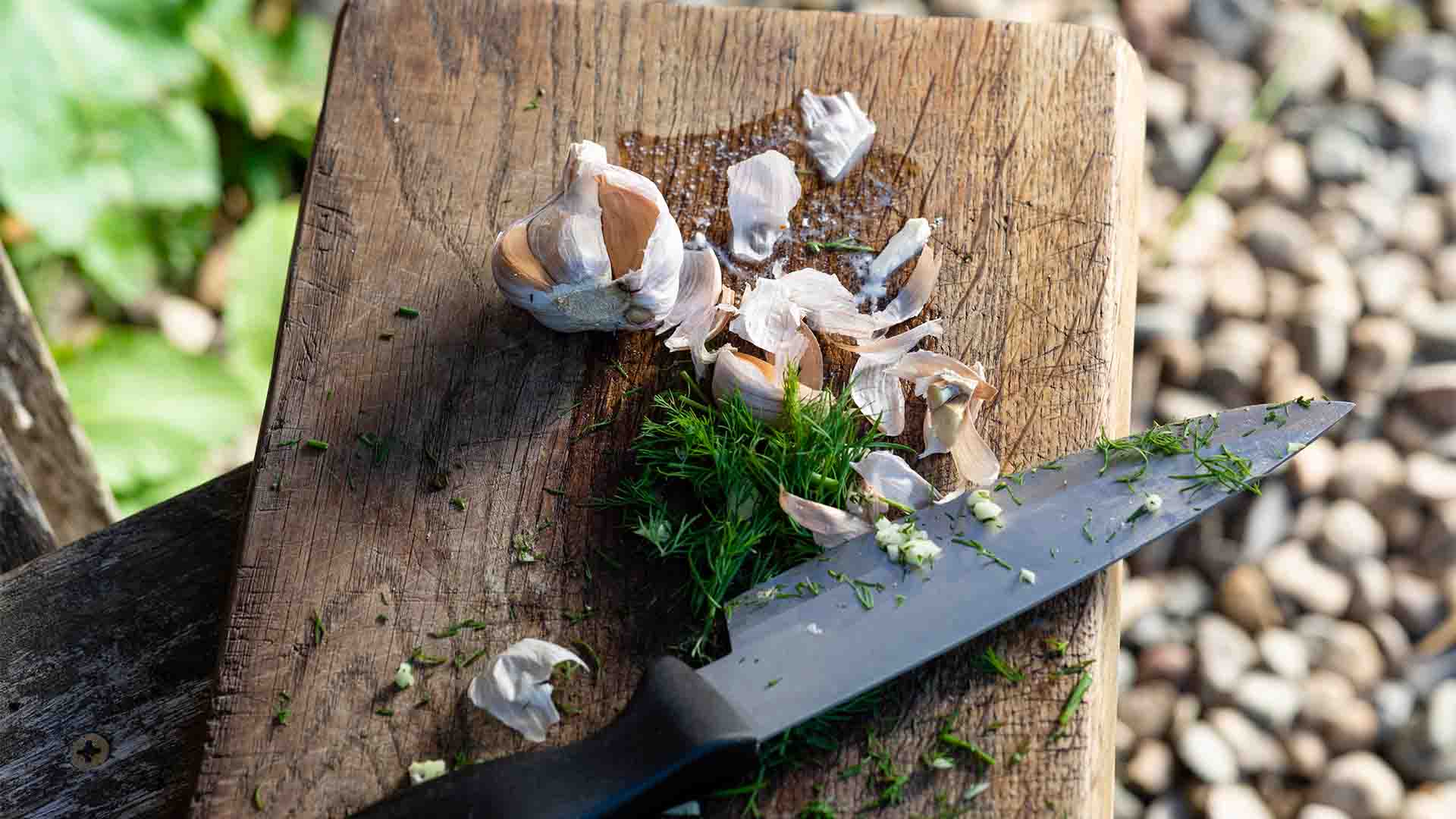 Preparing forraged ingredients on a wooden board with a knife