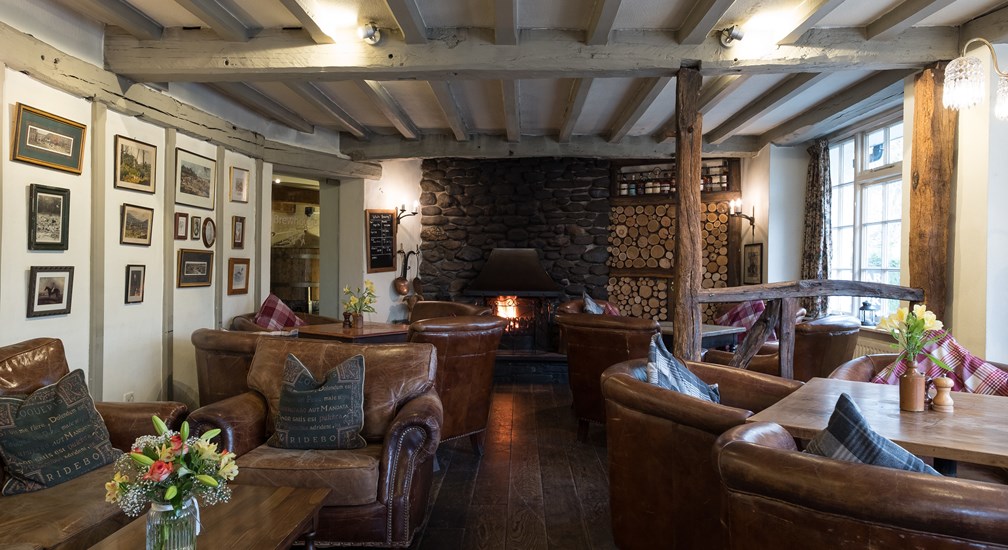 Cosy leather seats and log fire in the lounge at The Wild Boar