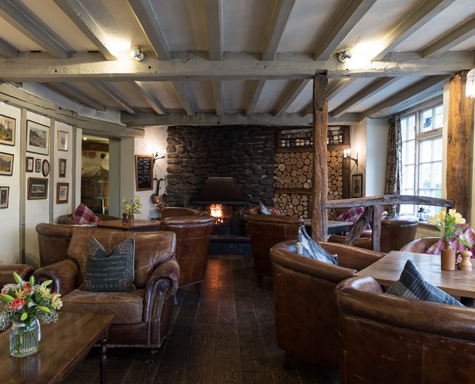 Cosy leather seats and log fire in the lounge at The Wild Boar