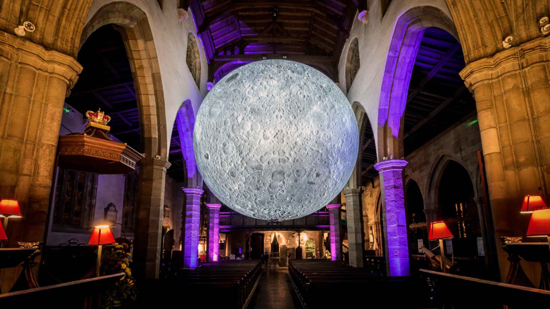 A model of the moon suspended in a church building.