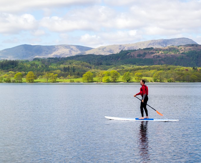 Single paddleboarder in front of Langdales