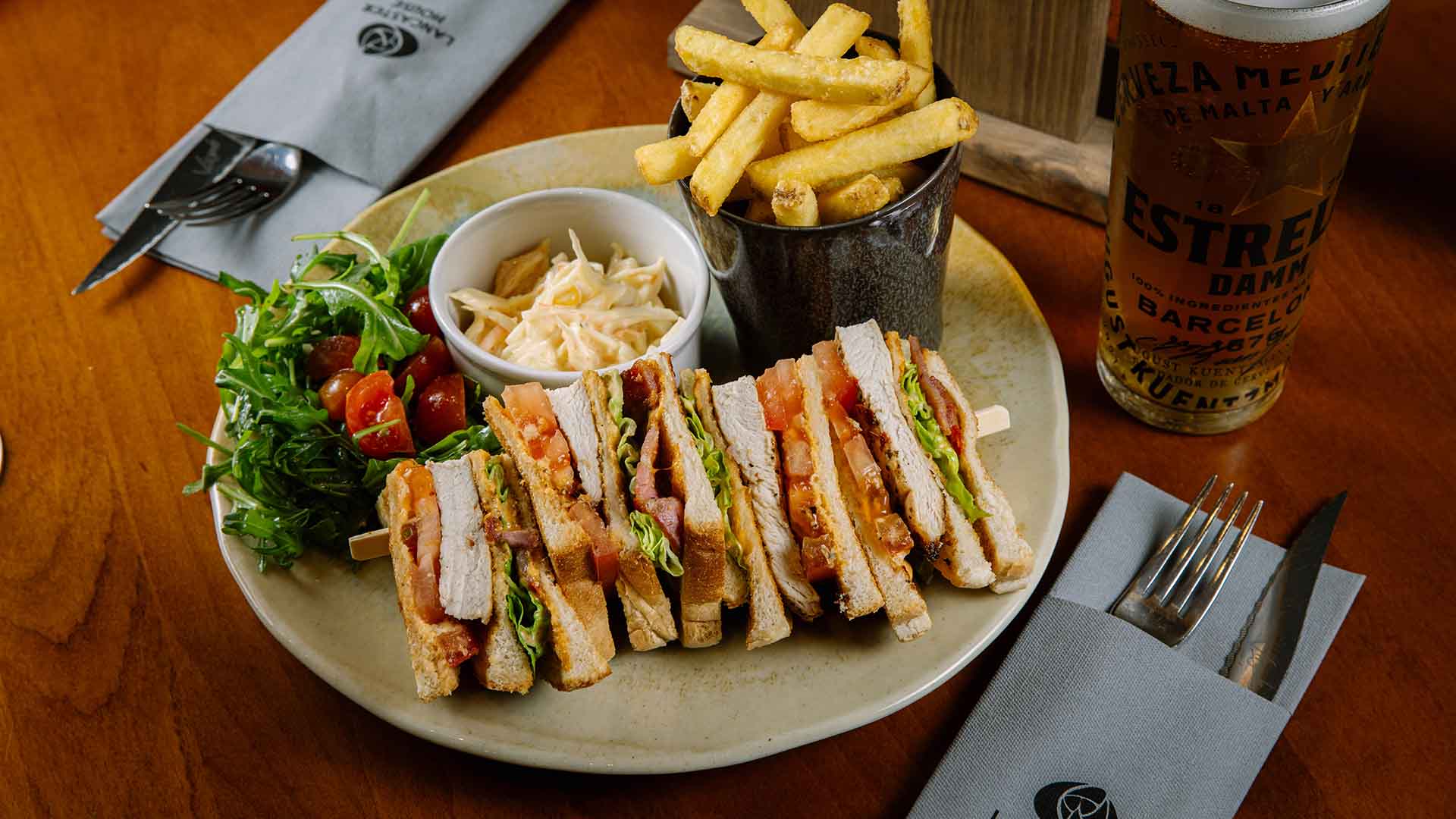 BLT sandwich with dressing and fries and a pint