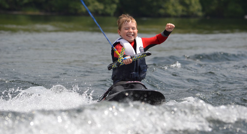 A child wakeboarding on Lake Windermere