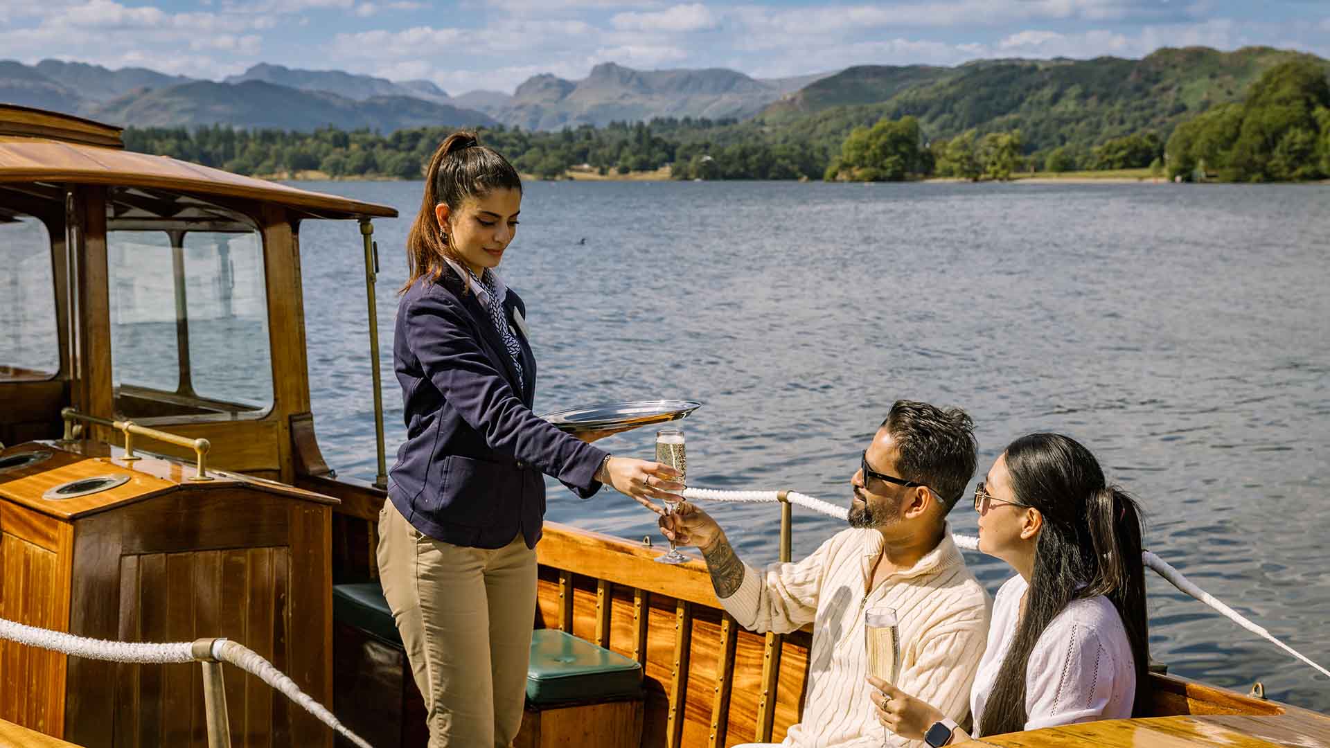 Drinks being served to a couple aboard Winander by a young woman