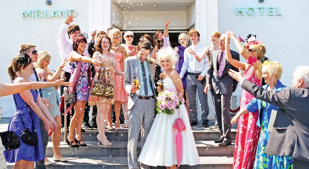 Wedding guests casting confetti on the Bride & Groom on The Midland Hotel entrance