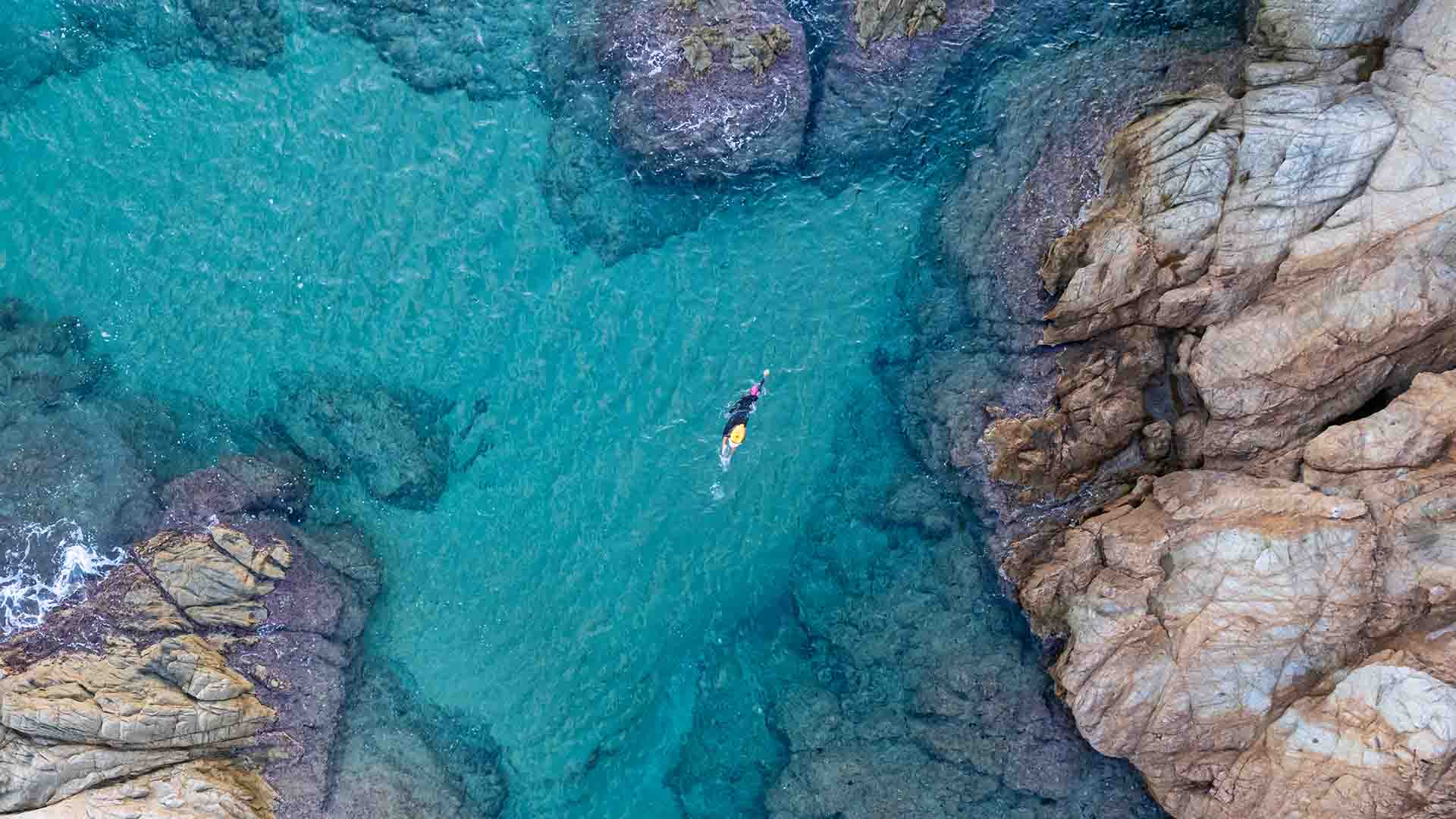 Swimmer in open water by the coast