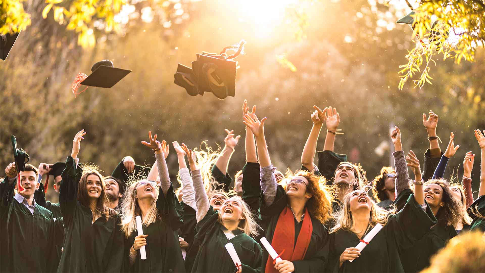University graduates throwing their boards into the air