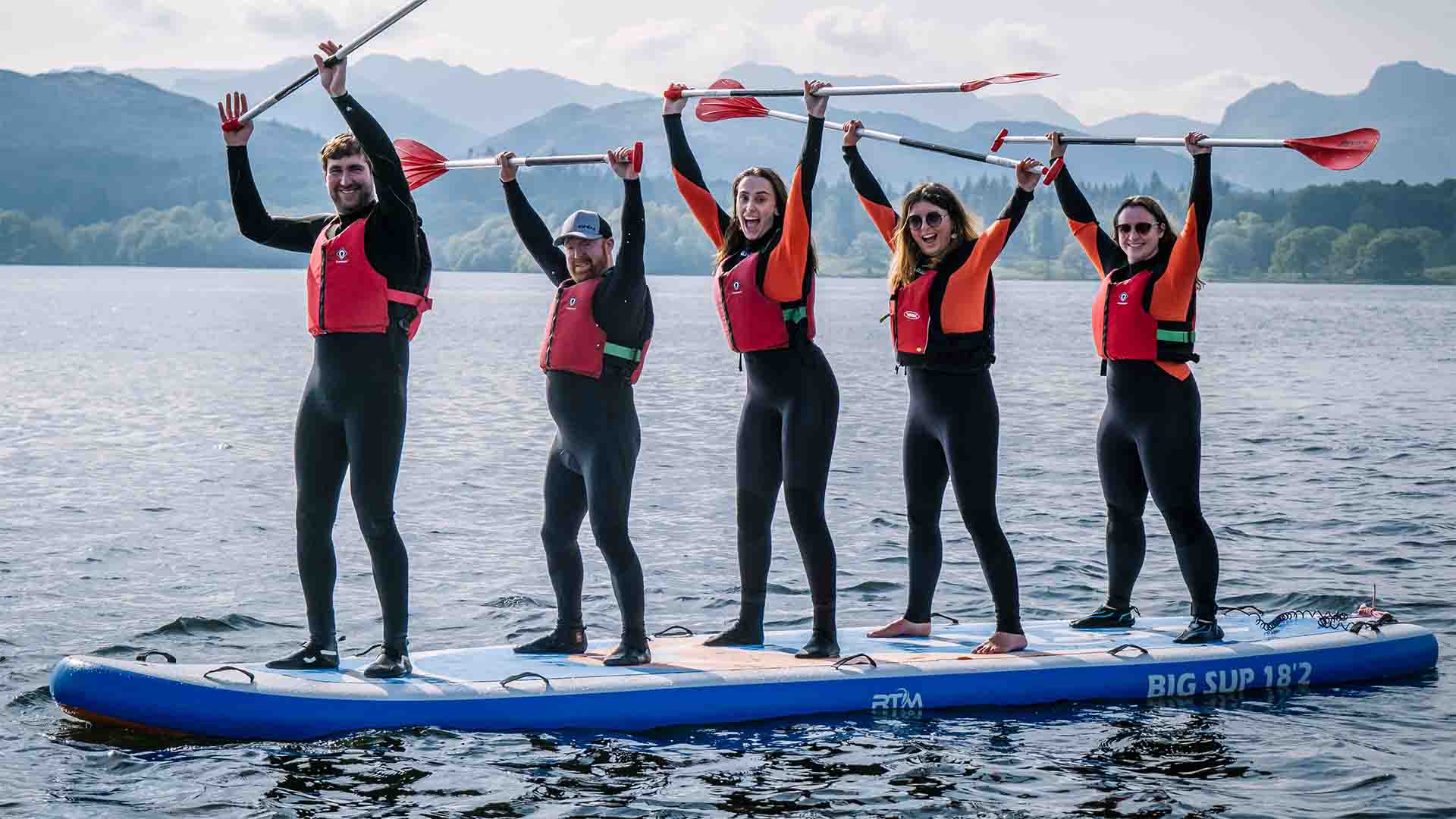 Group using the giant paddleboard on lake Windermere