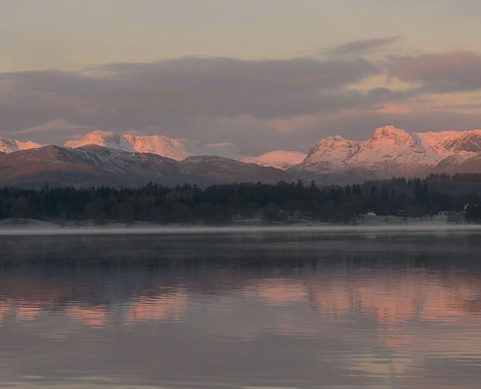 Pink morning light on a snowy Langdale from Windermere