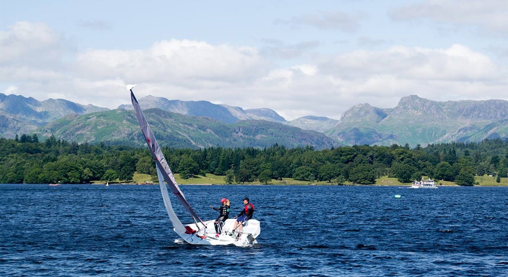 Sailing on lake Windermere with backdrop of the Langdale Pikes