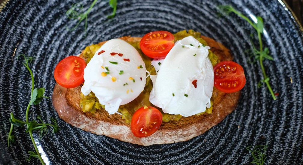 Poached egg, smashed advocado and cherry tomatoes on toast