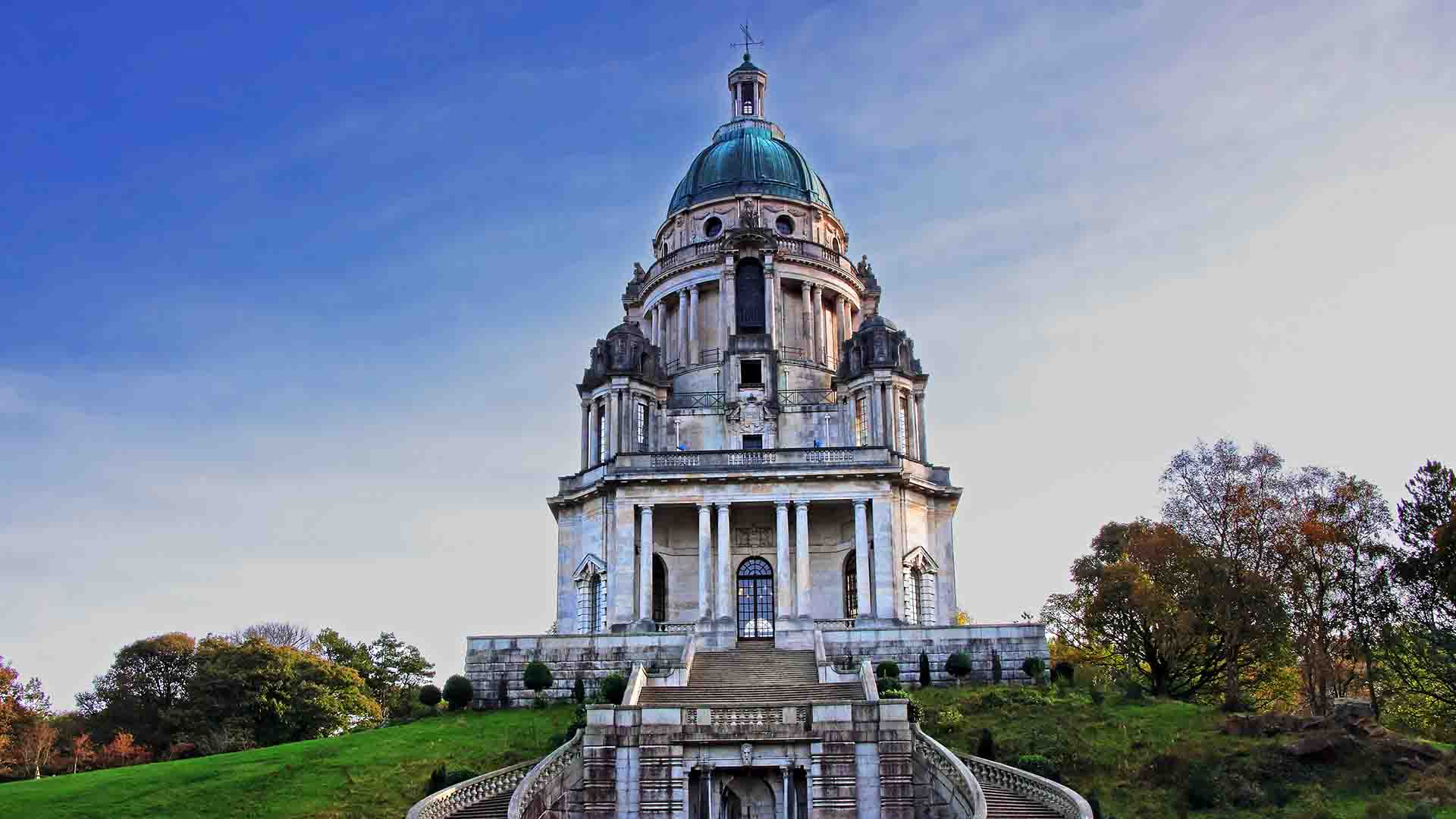 The Ashton Memorial in Lancaster with a small group of young people on the grass