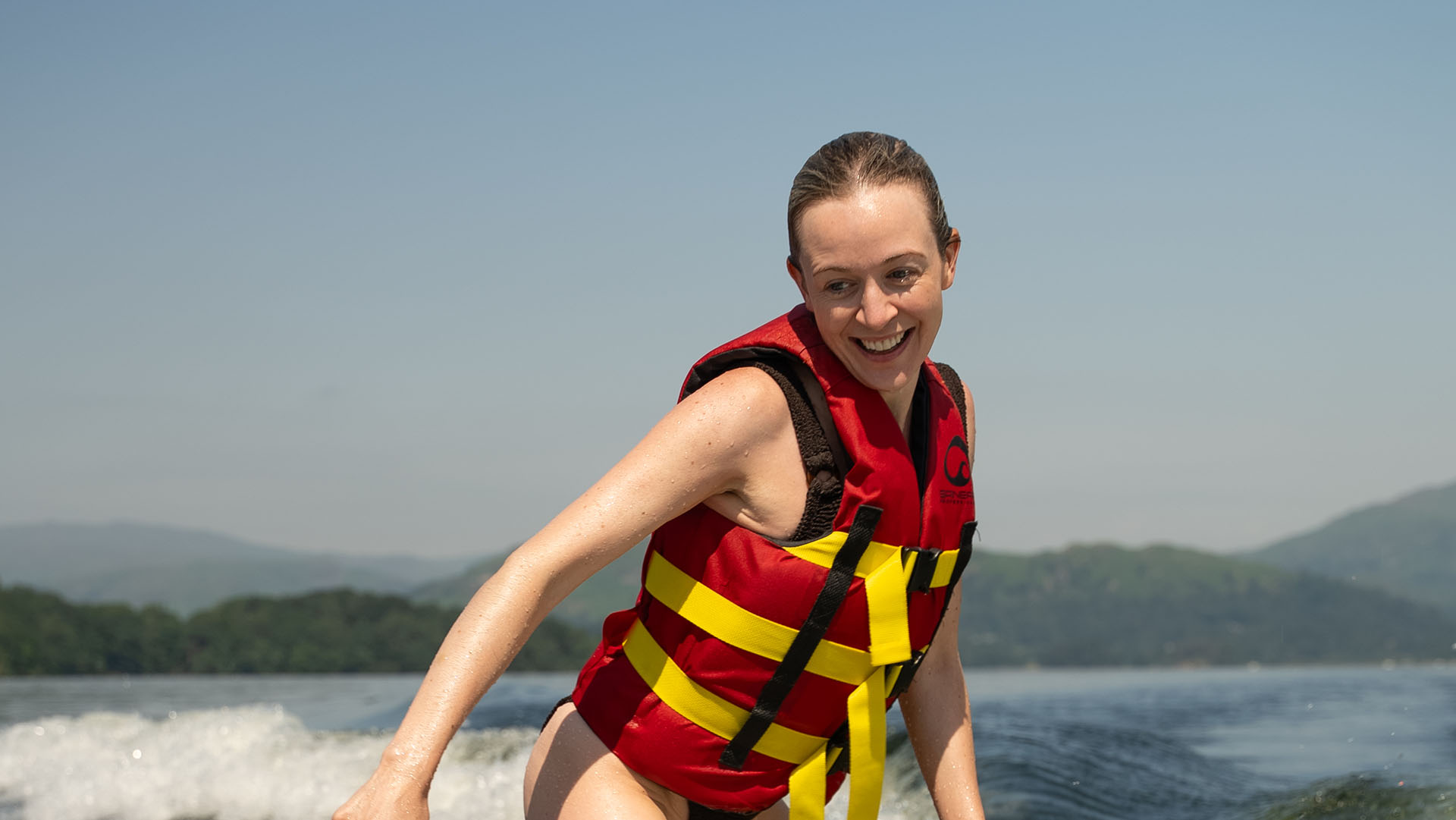 Close up of woman wakesurfing on lake Windermere