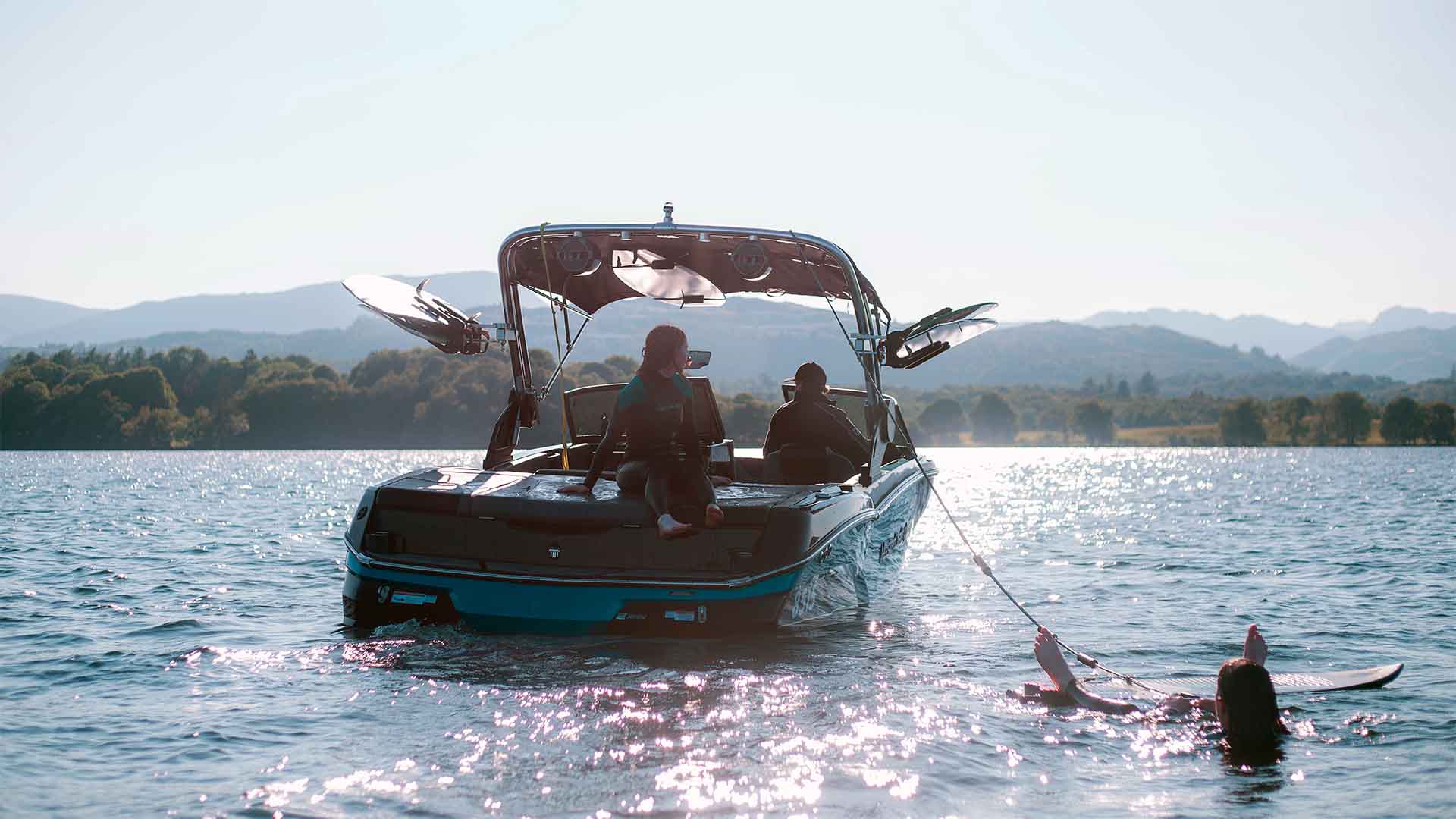 Young woman getting ready to wake surf on lake Windermere