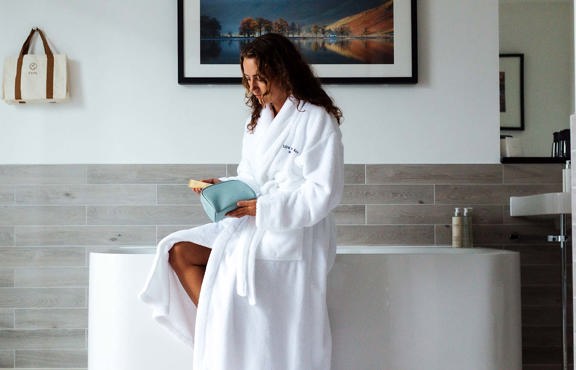 Young woman sat on the side of a bath