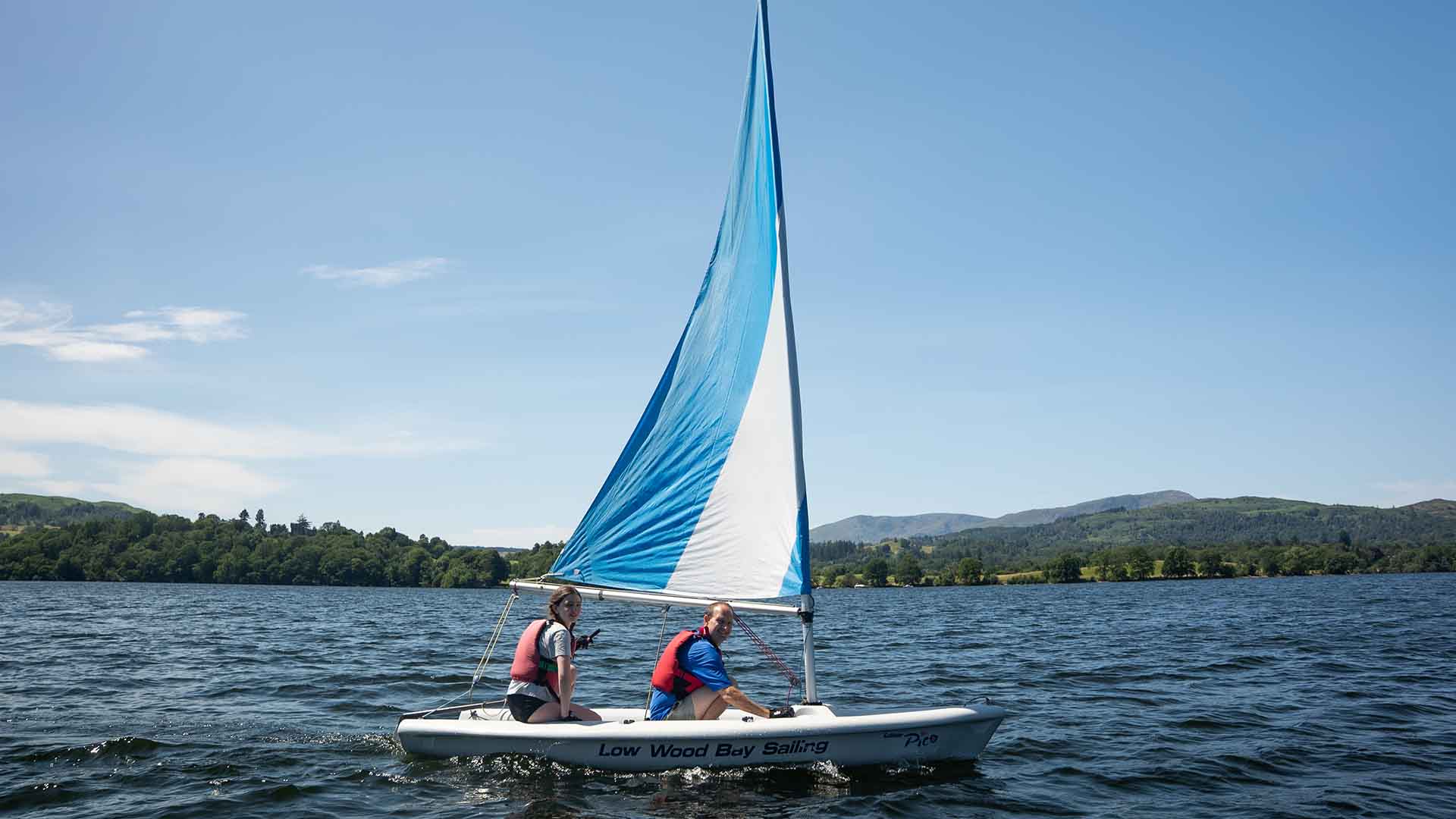 Two people sat in a pico sailing boat on lake Windermere