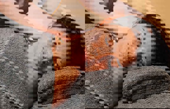 Young woman receiving a Signature Shoulder, Neck & Scalp Treatment