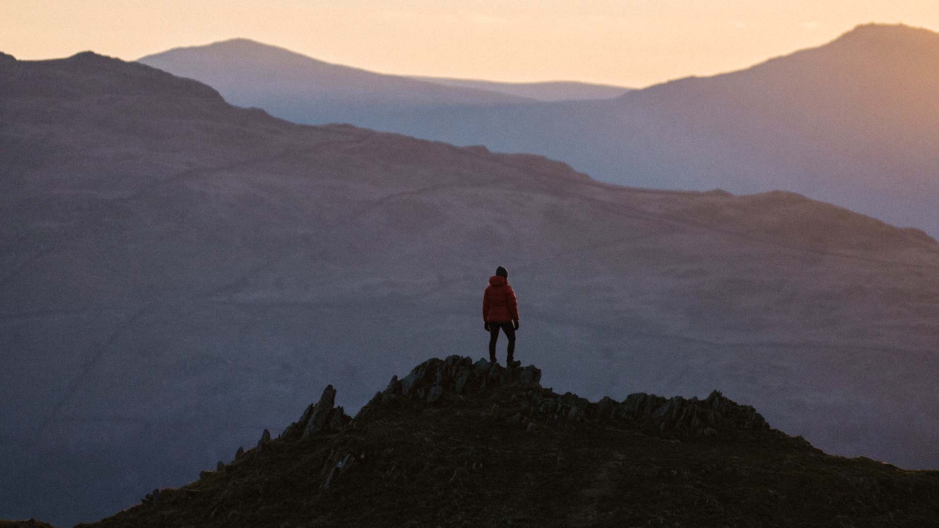 View of Loughrigg Fell with a walker silhouetted against the skyline