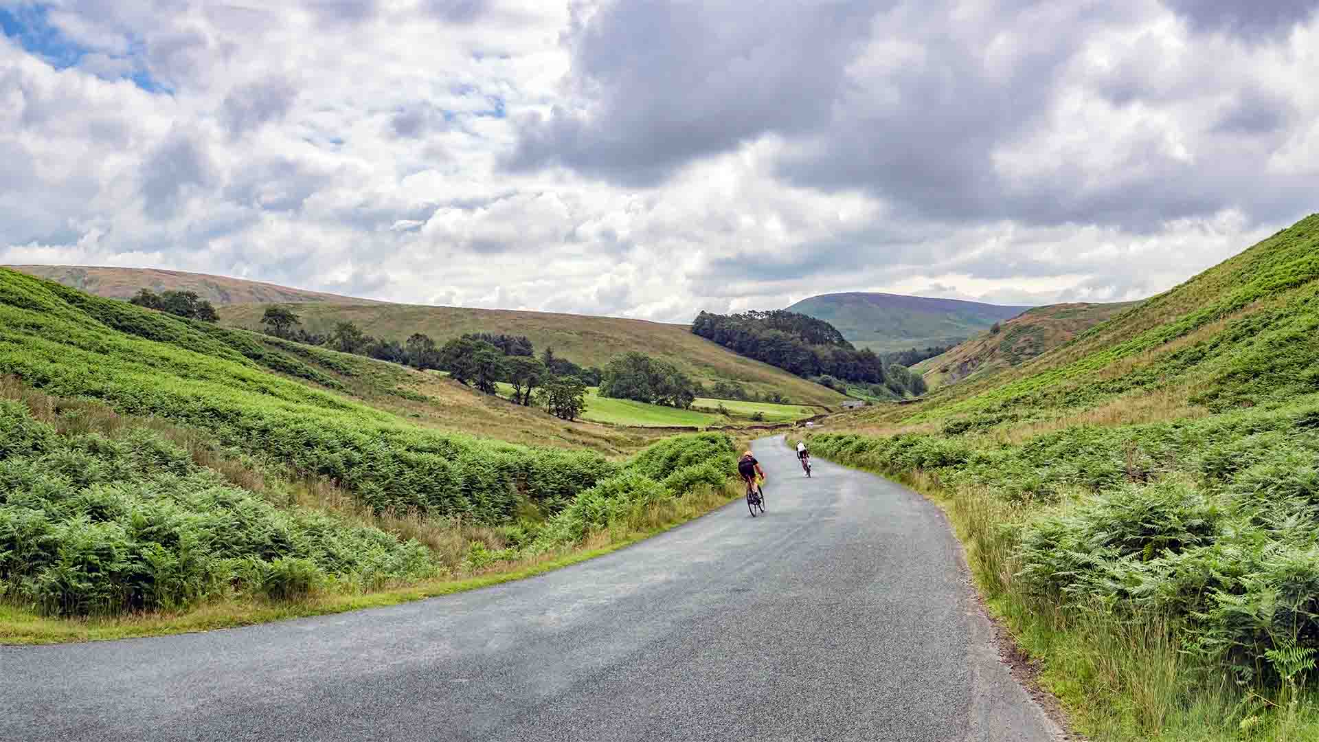 Two cyclists descending a hill in the Trough of Bowland in Lancashire