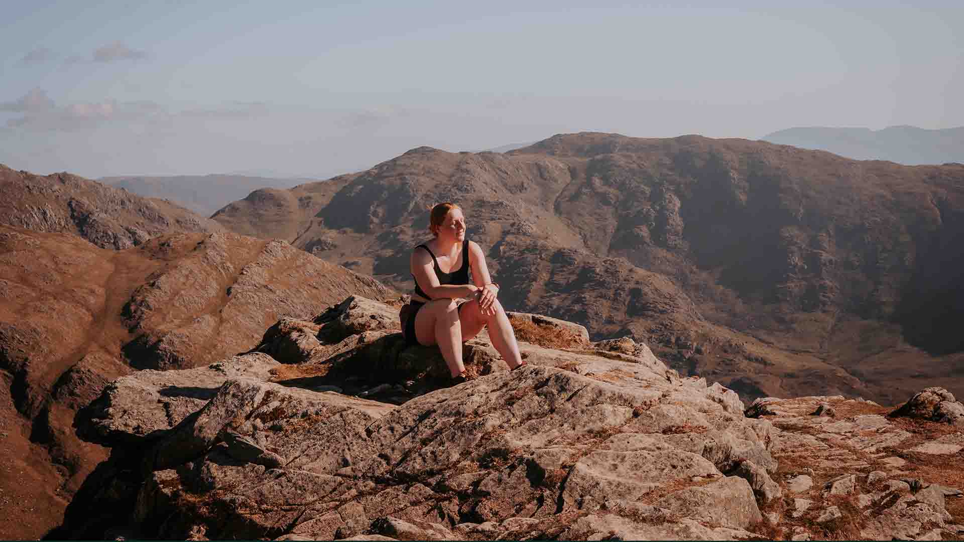 Clare sat on the top of a hill in the summer