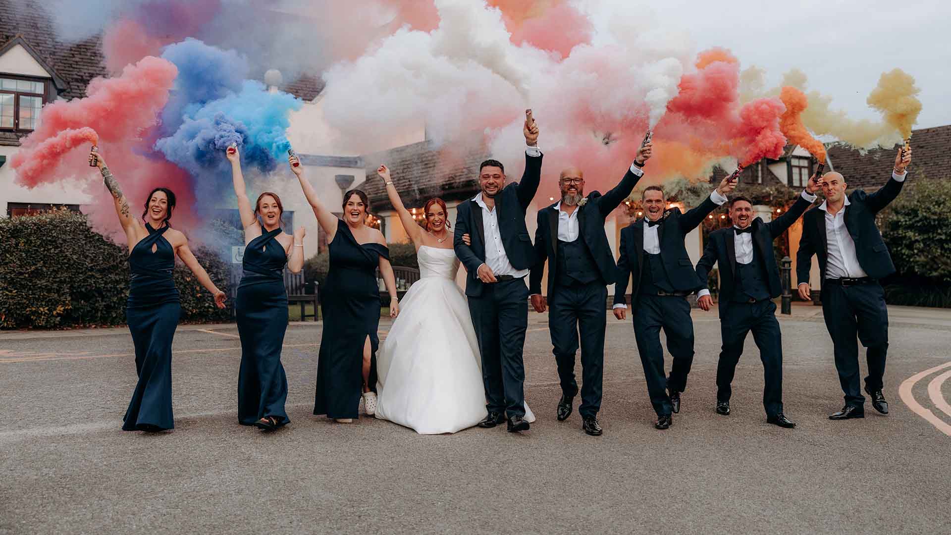 Wedding party with coloured flares by the entrance of Lancaster House Hotel