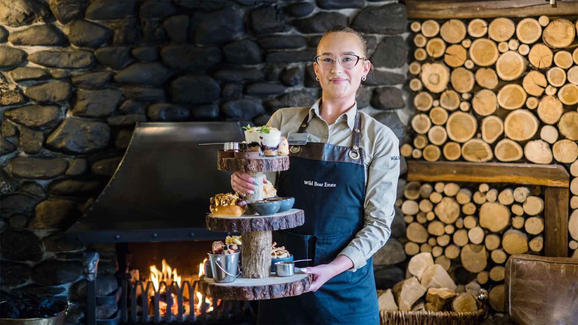Waitress holding an alternative afternoon tea at The Wild Boar Estate