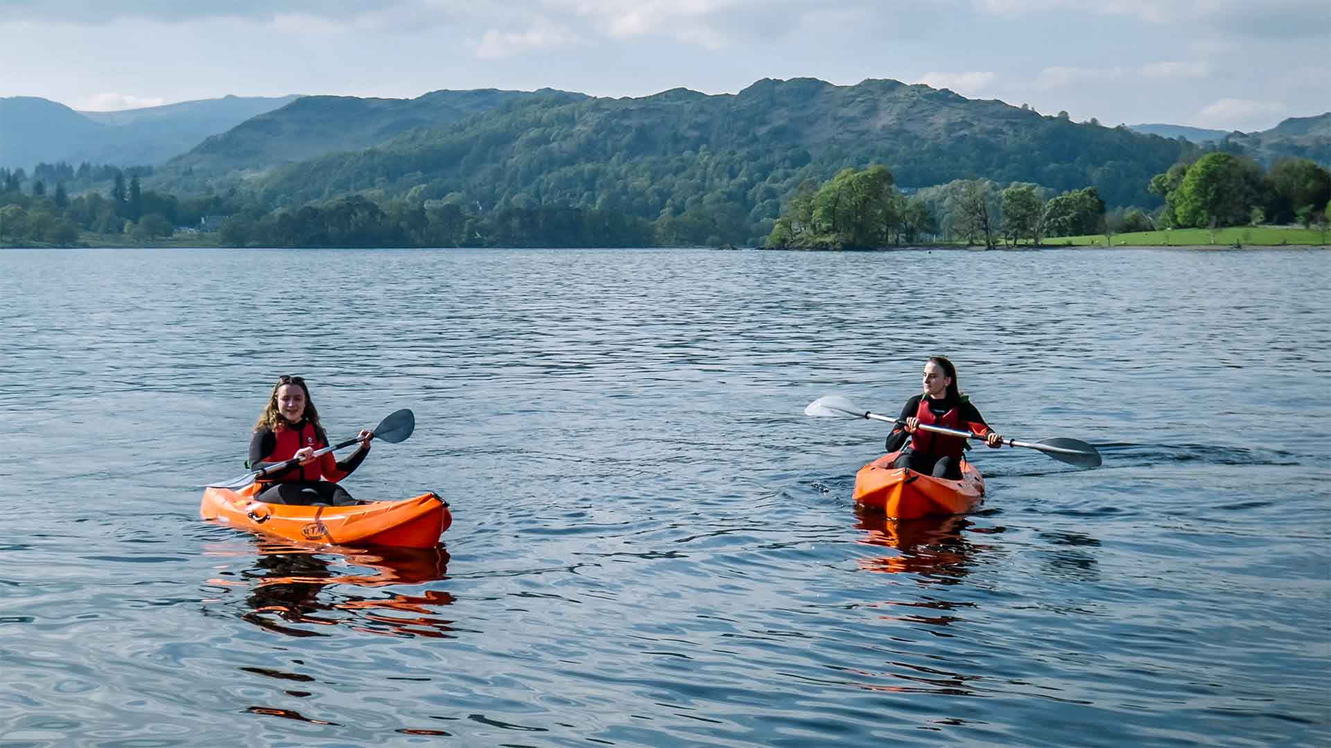 Two kayakers aboard hired kayaks on lake Windermere