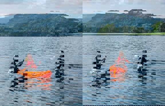 Two young women in kayaks on lake Windermere