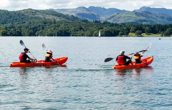 Family on two double sit-on-top kayaks on lake Windermere on a sunny day