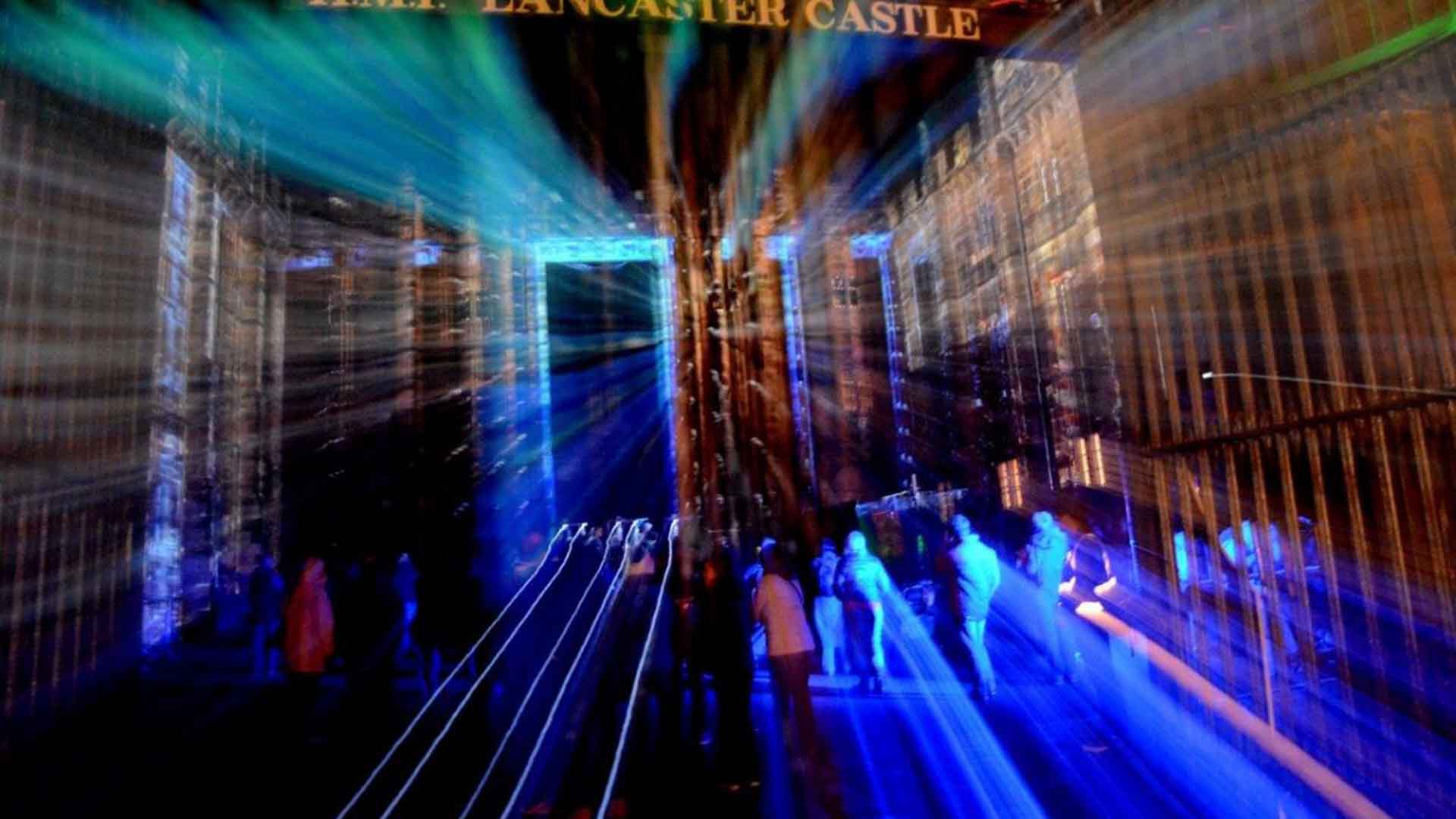 People backlit whilst stood in the grounds of Lancaster Castle Prison