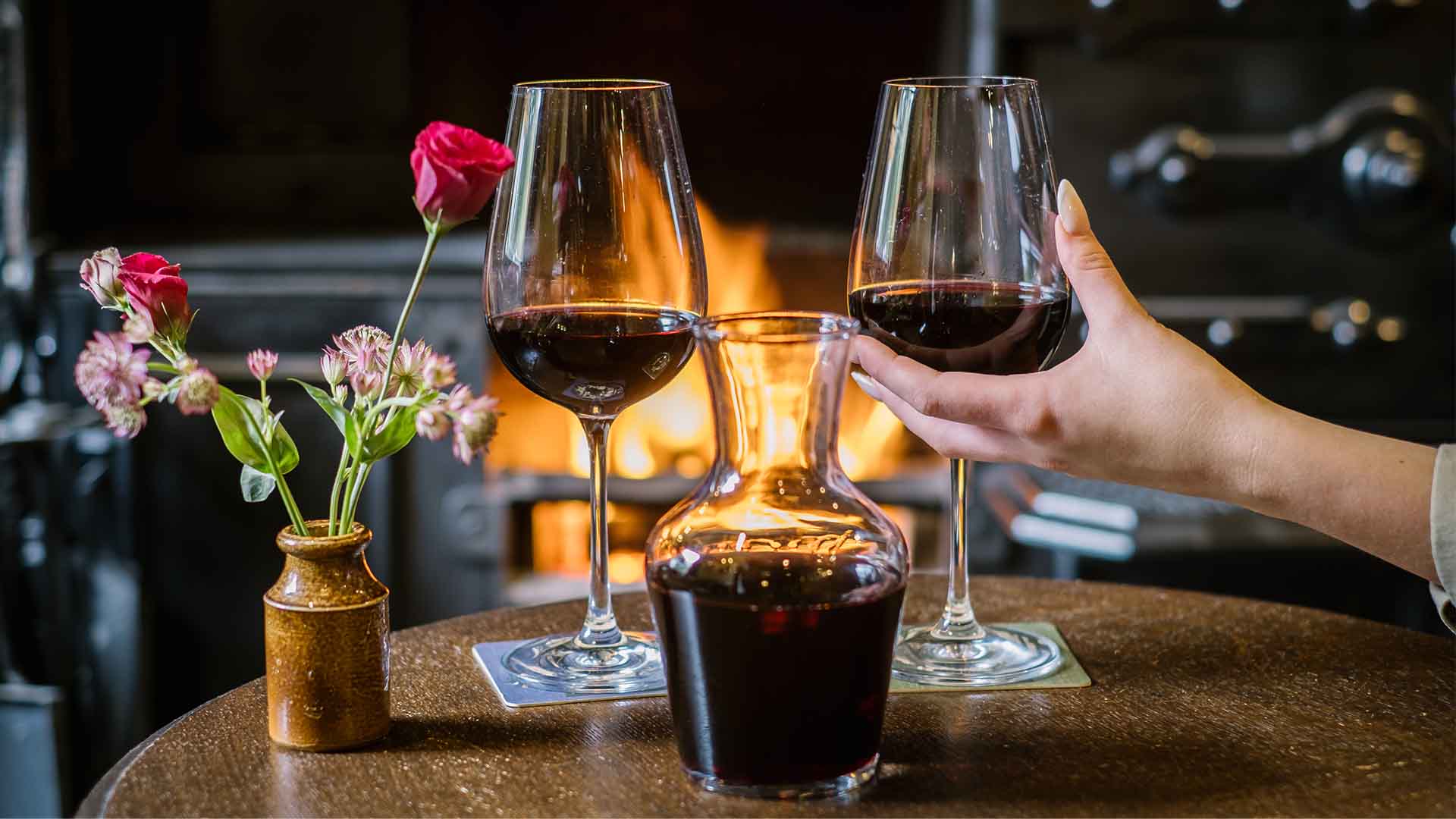 Glasses of red wine abd a carafe by the lounge fireside at Wild Boar Estate