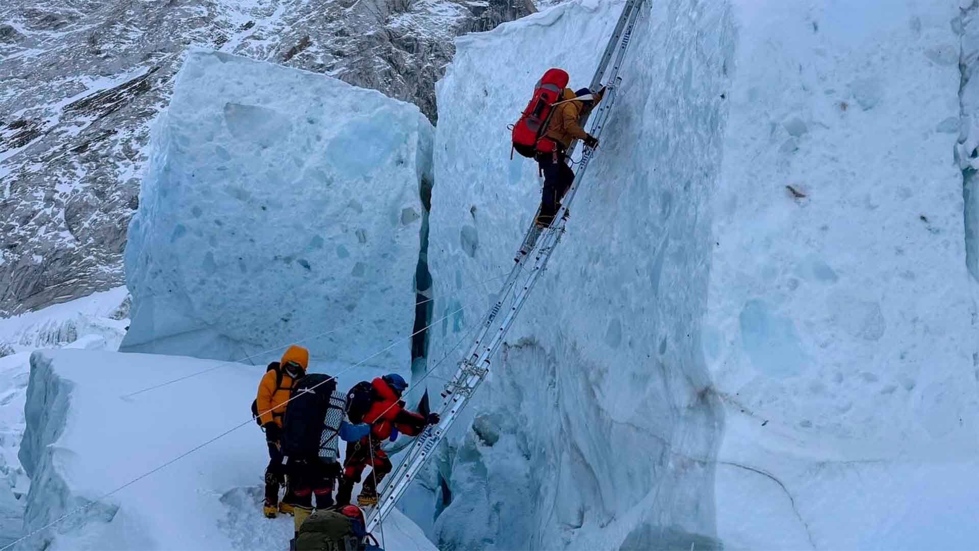 Mountaineers crossing the Khumbu ice fall using ladders