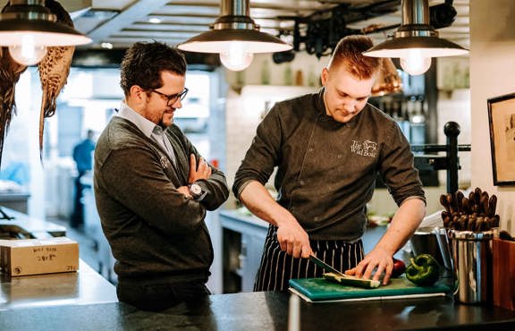 Adam watching chef prep food