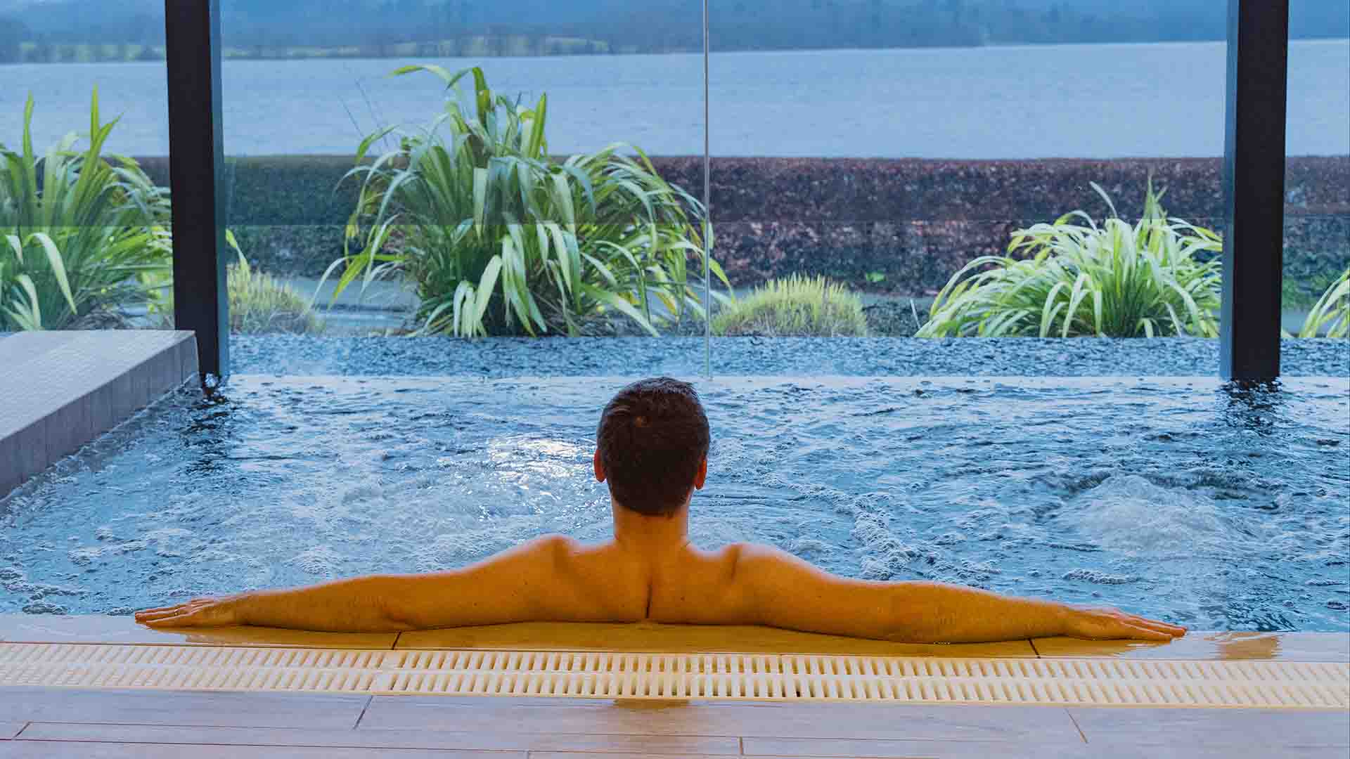 Young man in the indoor thermal pool at the spa