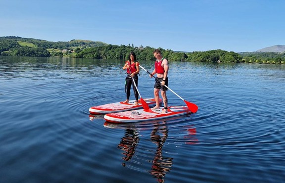 Couple stand up paddle boarding on Windermere