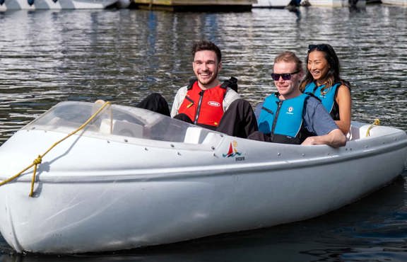 Three people in a hire pedalo boat on lake windermere