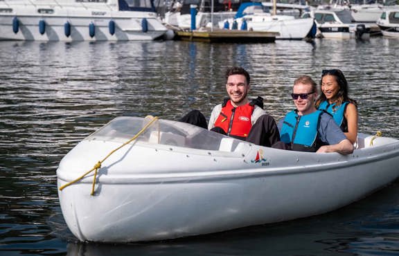 Three people in a hire pedalo boat on lake windermere