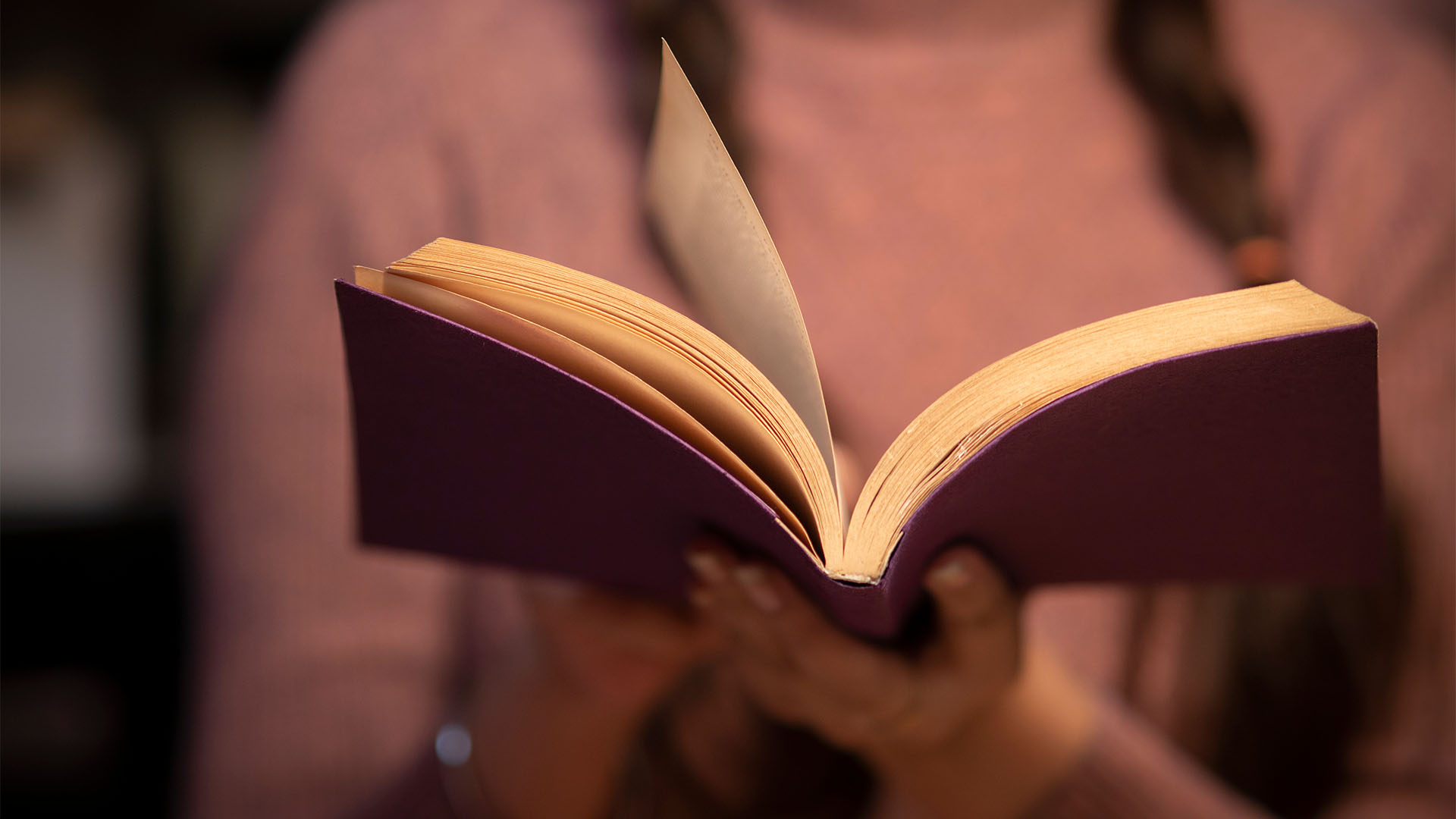 Woman reading from a book.