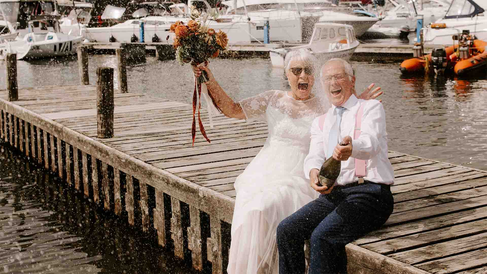 Older couple celebrating their wedding on the Low wood Bay Jetty