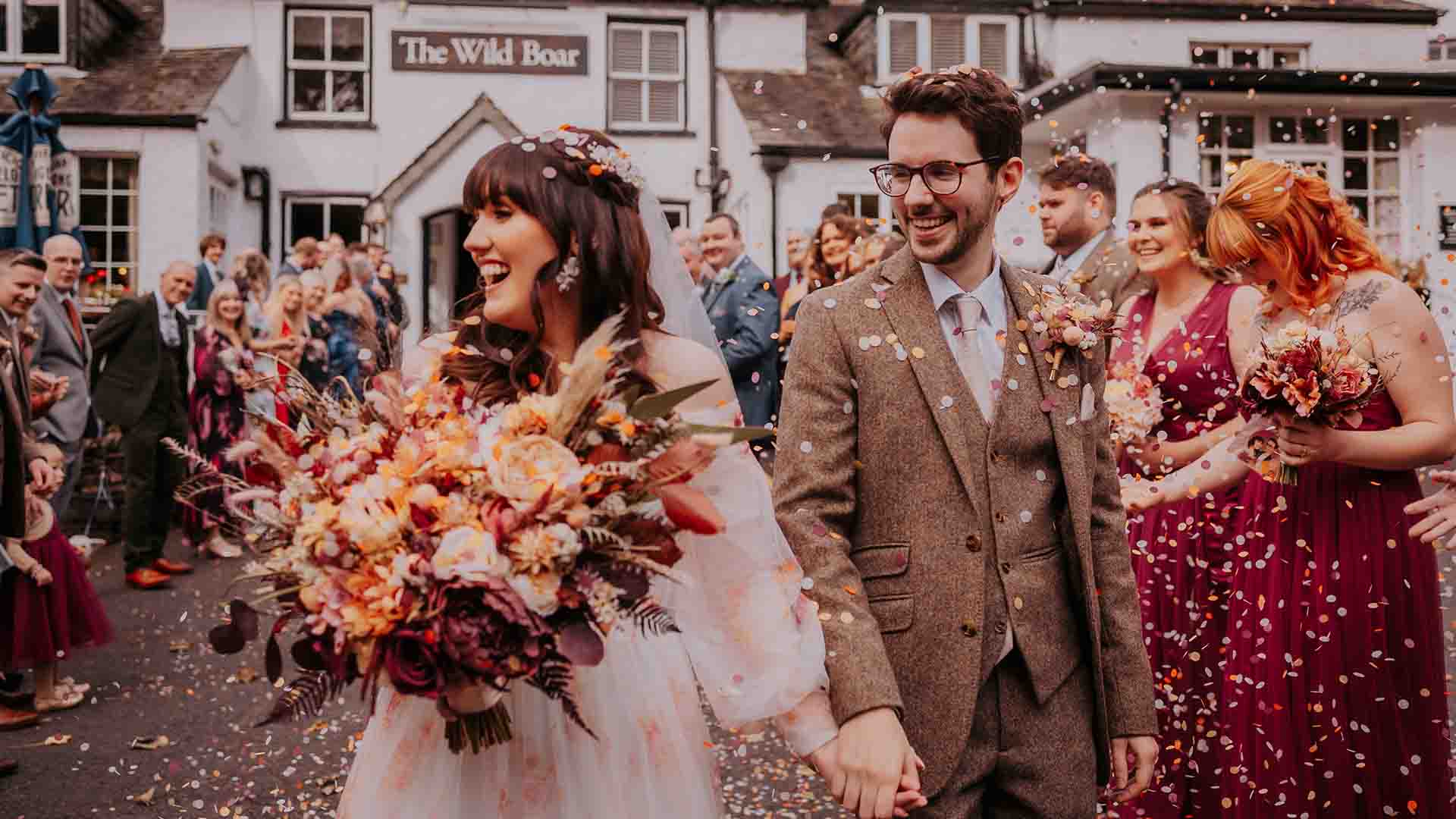 Guests throwing confetti over the married couple at Mr & Mrs Kendall's wedding at the Wild Boar Estate