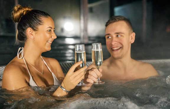 Couple relaxing in the outdoor hot tub at The Sandpiper Club