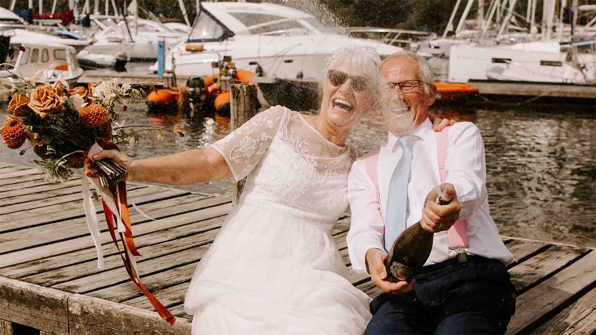 Older couple celebrating their wedding on the Low wood Bay Jetty