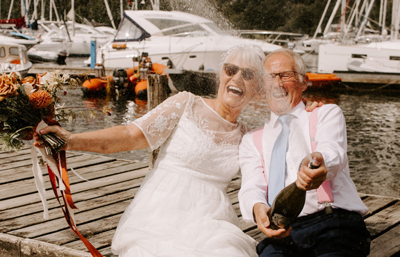 Older couple celebrating their wedding on the Low wood Bay Jetty