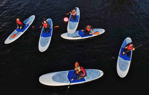 Birds eye view of paddleboarders on lake Windermere