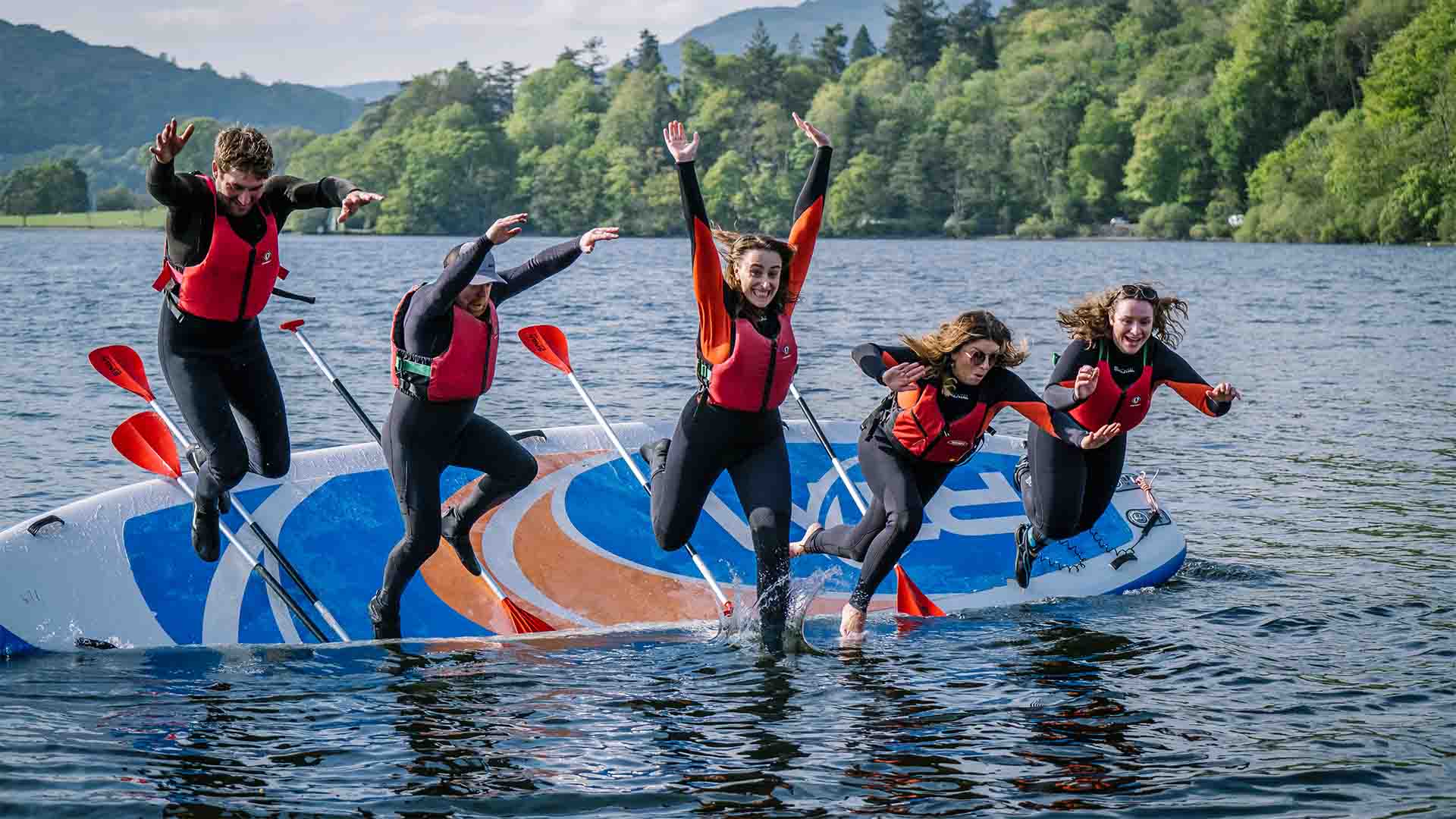 Group using the giant paddleboard on lake Windermere