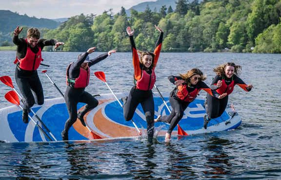 Group falling off the giant paddleboard into lake Windermere