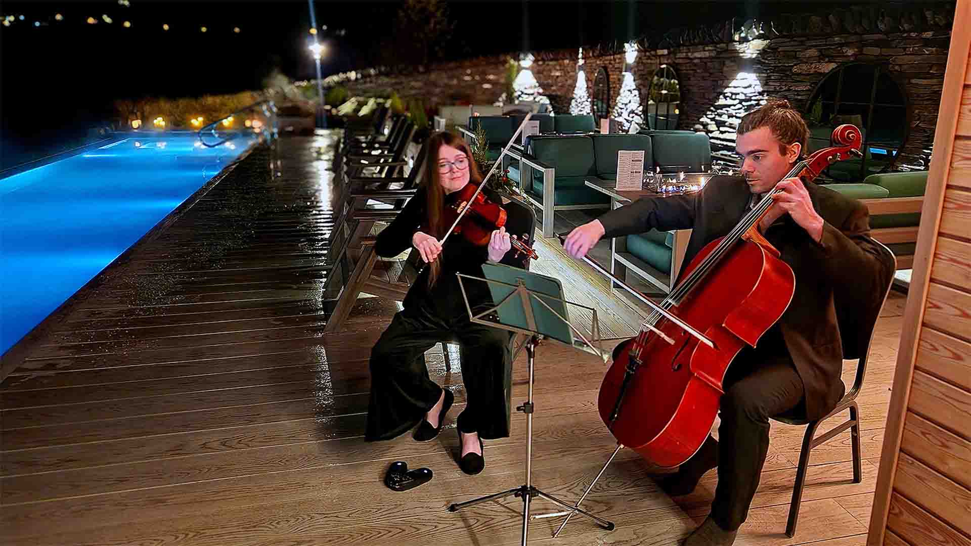 Musicians playing stringed instruments by the pool