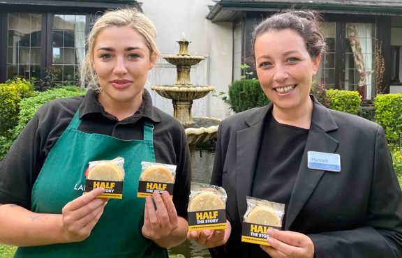 Two staff holding biscuits from Half the story bakery