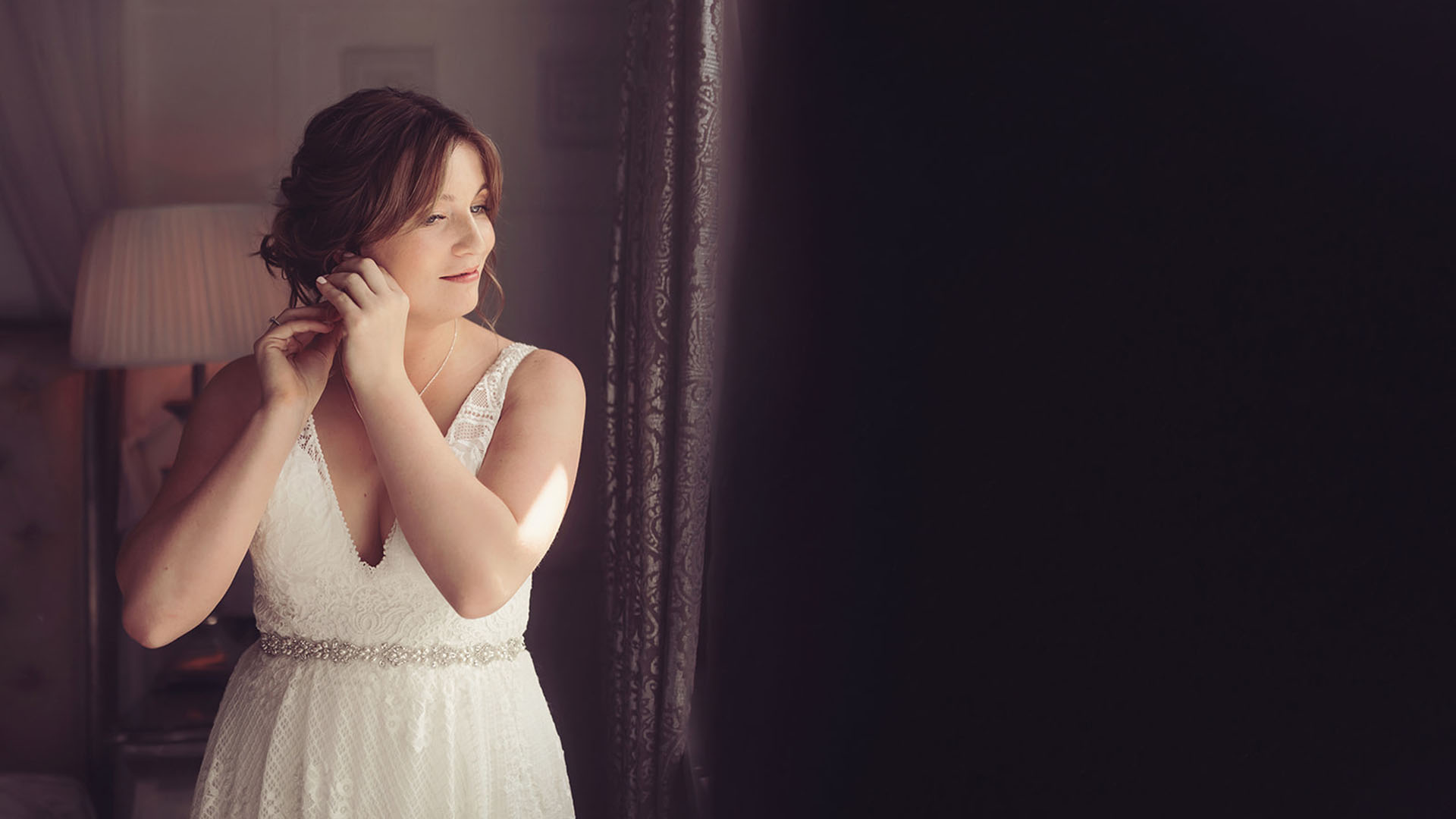 Bride putting an earring