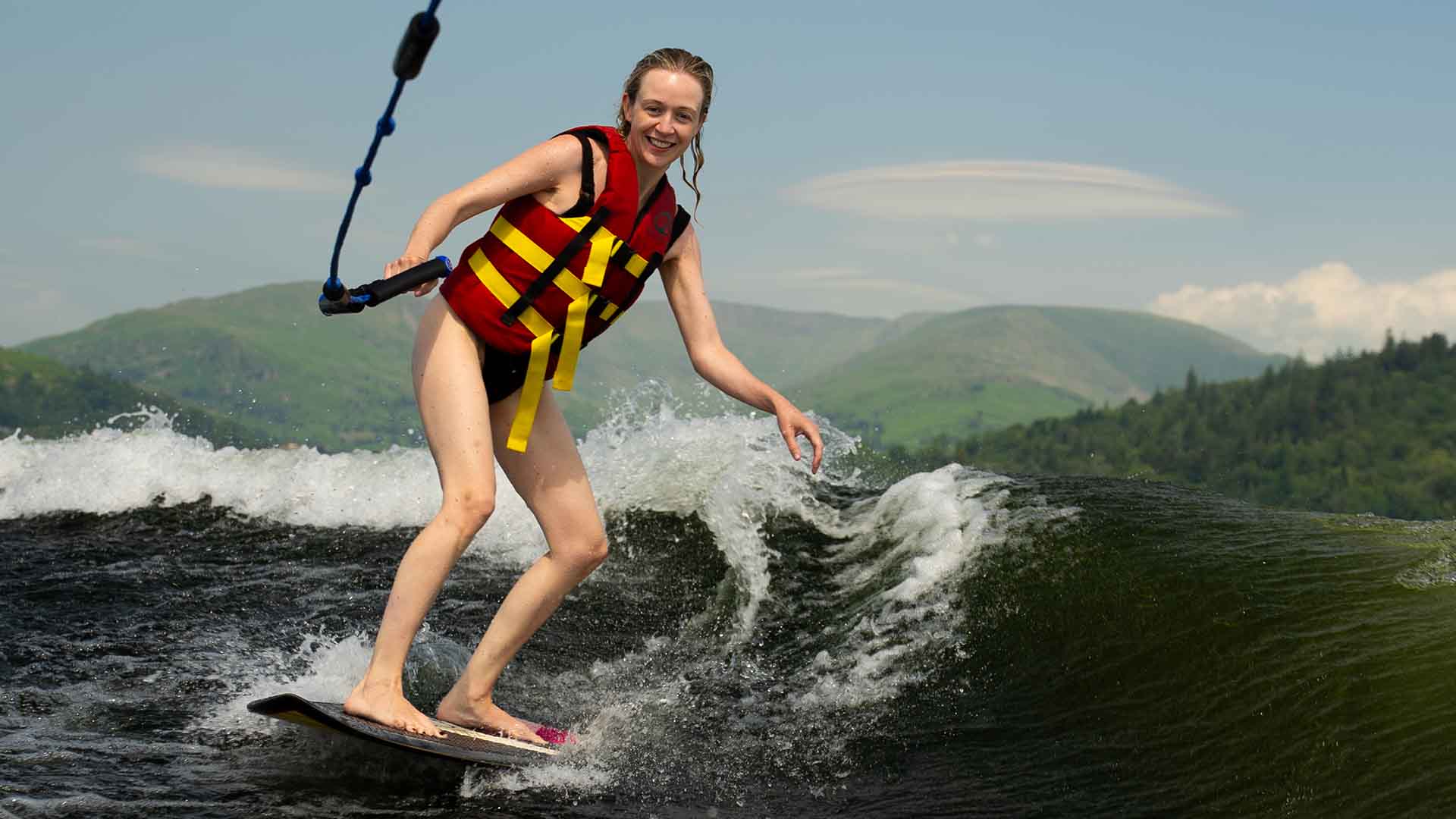 Young woman wakesurfing on lake Windermere